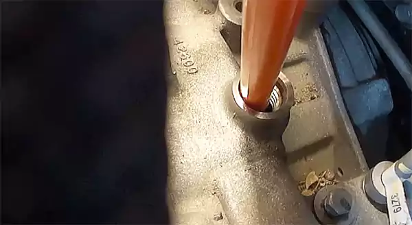 Putting the funnel into the fill plug